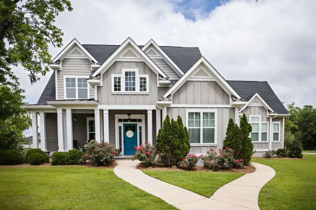 Light gray and white home with a bold blue front door by a house painter in Prosper, TX