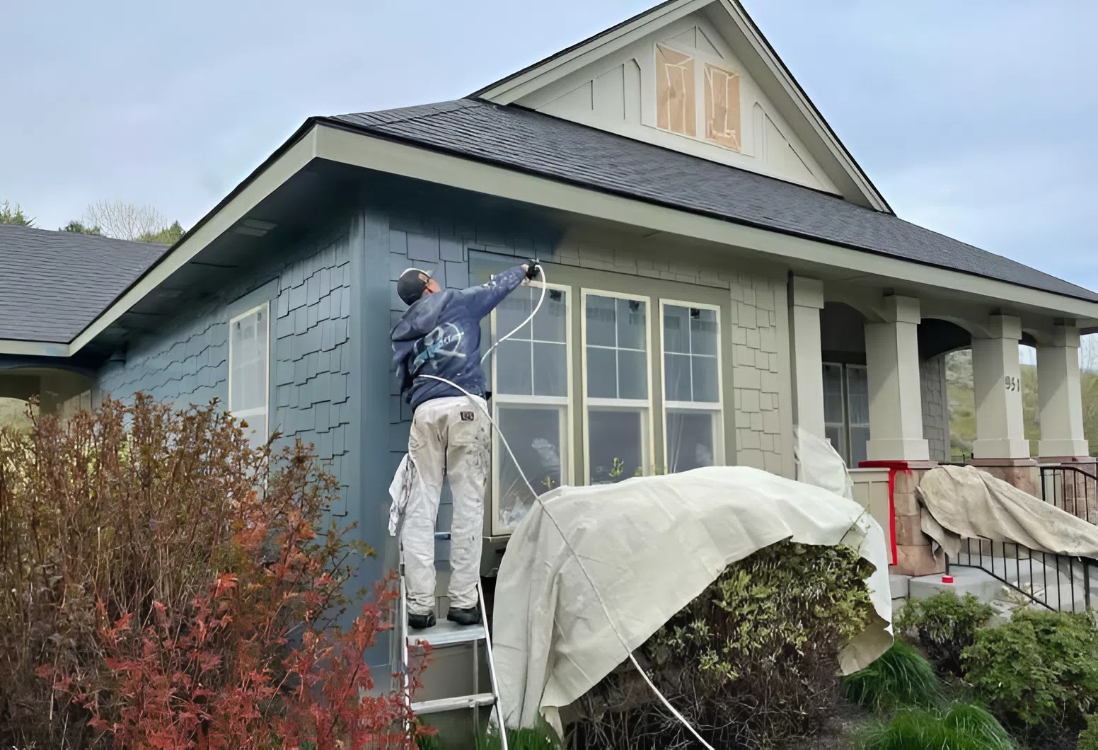 Professional house painter restoring weather-damaged siding and trim by an exterior painter in Prosper, TX