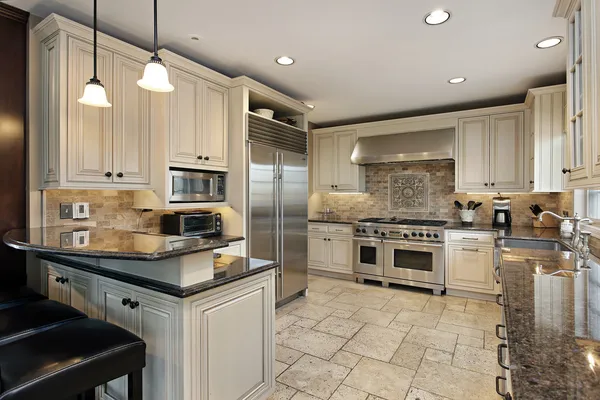Cream-colored kitchen cabinets with trim detailing and a smooth finish by cabinet painting in Richardson, TX.